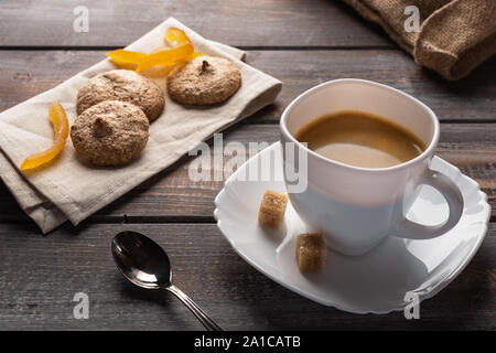 Tasse de café noir à la cuillère et de morceaux de sucre. À côté des biscuits sont sur une serviette et un sac de linge Banque D'Images