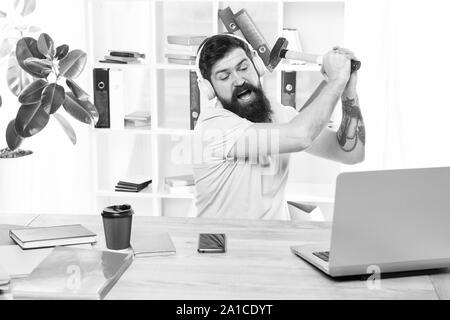 Connexion internet lente. Logiciel obsolète. Décalage de l'ordinateur. Pour des raisons du retard de l'ordinateur. Comment fixer la traîne lente du système. La routine du bureau. Homme barbu bureau écouteurs swing marteau sur ordinateur. Banque D'Images