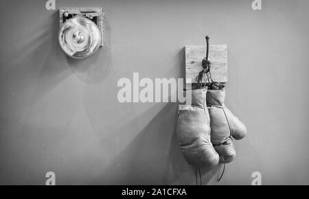 Histoire du sport. vintage gong et porté des gants. endurance. gong final au combat de boxe rétro vintage. équipements de sport.. concept de boxe gants de boxe ancien sur cintre. copier l'espace. Le combat final. Banque D'Images