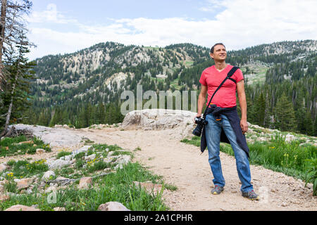 Albion, bassin d'été de l'Utah avec sentier rocheux en vue montagnes Wasatch touristiques avec l'homme debout sur la route vers le lac Cecret et fleurs sauvages Banque D'Images