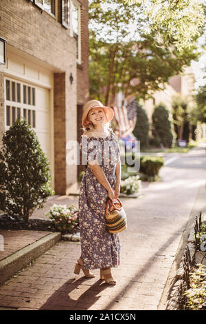 Milieu de femme porte ancienne mode vêtements dans les rues de la vieille ville d'Alexandria, VA Banque D'Images