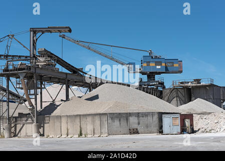 Une grue avec du gravier dans une gravière et différents types de pierre Banque D'Images