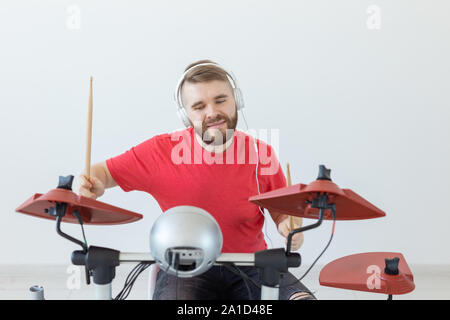 Émotions, batterie électronique et personnes concept - jeune homme batteur jouant du tambour. Banque D'Images