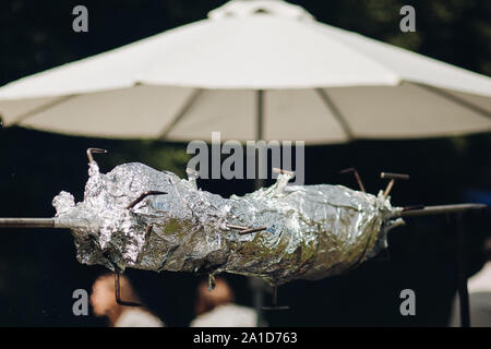 Porc grillé appétissant en aluminium sur le Spit. Banque D'Images