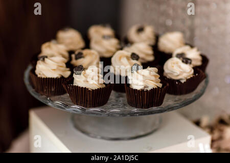 Petits gâteaux au chocolat. Muffins au chocolat maison. Le processus de faire des petits gâteaux au chocolat avec crème fouettée et décoré avec du chocolat. Sel Banque D'Images