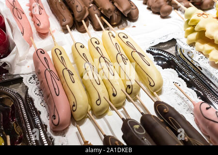Fruits bananes, fraises, noix, pommes, pêches couvert de chocolat blanc et noir. Banque D'Images