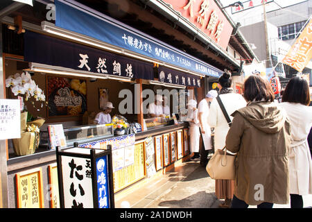 Les Japonais et les voyageurs étrangers sont ligne d'attente pour acheter en boutique de taiyaki Naritasan Omote Sando ou vieille ville de Narita à Tokyo le 31 mars Banque D'Images