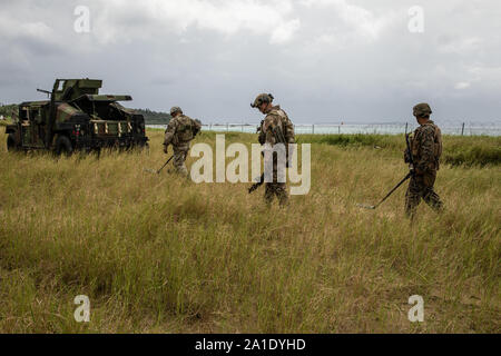 Le sergent du Corps des Marines des États-Unis. Jonathan Whitby (droite), U.S. Air Force aviateur Senior Benjamen Dring et le sergent de l'armée américaine. James Ahn raflent les mines antipersonnel lors d'une neutralisation des explosifs et de l'exercice dans la zone d'entraînement Bleu Kin, Okinawa, Japon, le 19 septembre 2019. L'EOD exercice a été conçu pour simuler la guerre classique et l'utilisation de munitions conventionnelles et impliqué la participation de trois branches militaires des États-Unis et plus de 43 groupes professionnels militaires différentes spécialités dans III Marine Expeditionary Force. Whitby, originaire de Tempe, Arizona, est une entreprise de NEM NEM technicien à l'ingénieur, 9e Banque D'Images