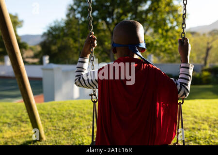 Super Héros boy in garden Banque D'Images
