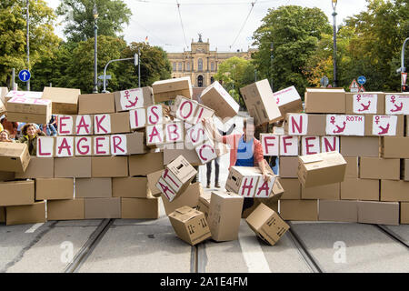 26 septembre 2019, Bavaria, Munich : les participants d'une action contre les centres d'abattre un mur de cartons de déménagement avec l'inscription 'briser l'isolement - Lager Abschaffen' et les noms des divers centres d'ancre en face de la parlement bavarois. La raison de l'action est une audition d'experts sur les centres d'ancrage dans le Parlement de Bavière. Le Conseil des réfugiés de Bavière, réfugiés lutte pour la liberté, la caravane Munich et anker-watch.de la demande avec leur action sous la devise 'briser l'isolement ! D'autres auditions d'experts dont les réfugiés ont également leur mot à dire. Photo : Matthias Balk/dpa Banque D'Images