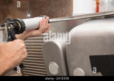 Le silicone est appliqué aux réservoirs en acier inoxydable Banque D'Images