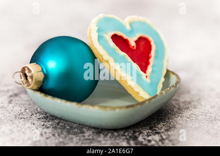 De délicieux cookies en forme de coeur et bleu boule de noël sur un tableau gris Banque D'Images