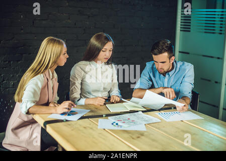 Équipe de jeunes collègues de story-board pour regarder des enregistrements vidéo en bureau coworking modernes. Processus d'équipe. ,Horizontal arrière-plan flou. Banque D'Images