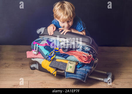 Baby Boy et voyage Valise. Kid et assurance paniers pour des vacances pleine de vêtements, enfant et voyage en famille. Banque D'Images