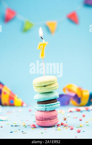 7ème 7ème carte d'anniversaire avec une bougie en macarons colorés et paillettes. Maquette de la carte. Banque D'Images