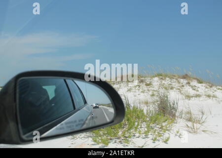 Voiture rétroviseur shot - Ciel bleu et sable blanc. Banque D'Images