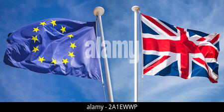 Brexit concept. Le drapeau national du Royaume-Uni et de brandir le drapeau de l'Union européenne sur le vent dans des directions opposées sur fond de ciel bleu Banque D'Images