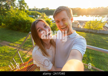 La Capture de moments lumineux. Jeune couple aimant joyeux drôle de caméra alors que sur selfies standing outdoors Banque D'Images