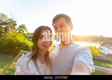 La Capture de moments lumineux. Jeune couple aimant joyeux drôle de caméra alors que sur selfies standing outdoors Banque D'Images