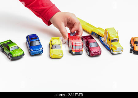 Enfant jouant garçon joue avec toy cars close up sur les mains Banque D'Images