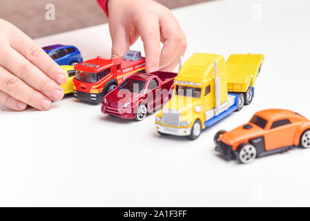 Enfant jouant garçon joue avec toy cars close up sur les mains Banque D'Images