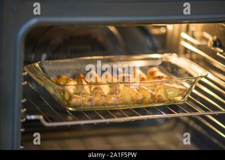 Pomme de terre cuite au four avec des tranches de prêt d'épices se trouvent dans le verre plat au four. Banque D'Images