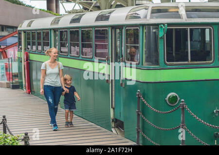 Maman et son fils vont aller sur un vieux tramway. Voyager avec des enfants à Hong Kong concept. Banque D'Images