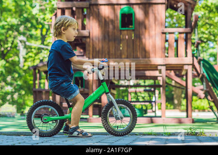 Garçon jouant avec fidget spinner. Spinner spinning enfant dans l'aire de jeux. Arrière-plan flou. Banque D'Images