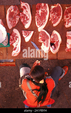 Vue aérienne de la femme travaillant dans la rue du marché de la viande de Lhassa, Tibet Banque D'Images