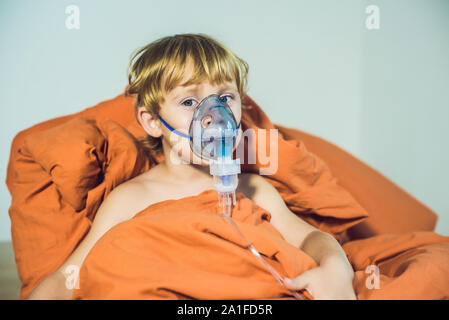 Boy making inhalation avec un nébuliseur à la maison. Banque D'Images