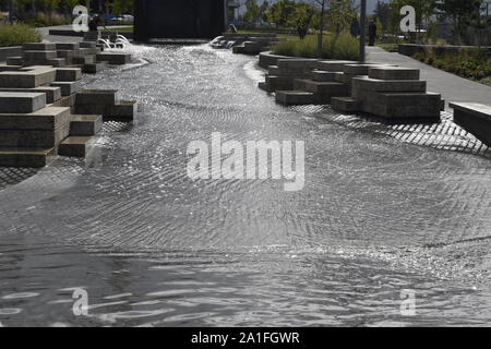 L'eau scintille comme il s'écoule des fissures dans les blocs de pierre et en bas d'un canal de nouvelle fonctionnalité de l'eau du fleuve Columbia à Vancouver Waterfront Park. Banque D'Images