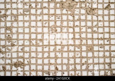 Mur recouvert d'un vieux carré blanc carreaux, morceaux visibles de ciment Banque D'Images