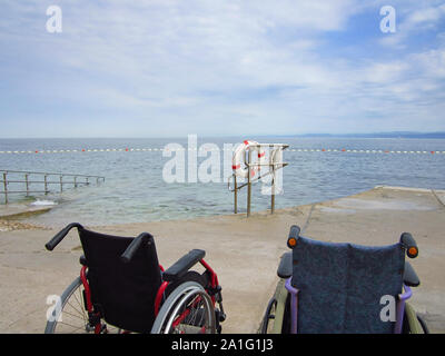 Fauteuil roulant sur une plage accessible pour le transport des personnes handicapées dans l'eau. Banque D'Images