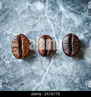 Trois types de grains de café sur un en arrière-plan. Les grains de café foncé sur fond rustique. Image symbolique. Close up. Vue d'en haut. Banque D'Images