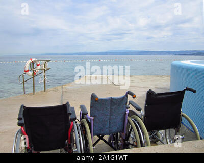 Fauteuil roulant sur une plage accessible pour le transport des personnes handicapées dans l'eau. Banque D'Images