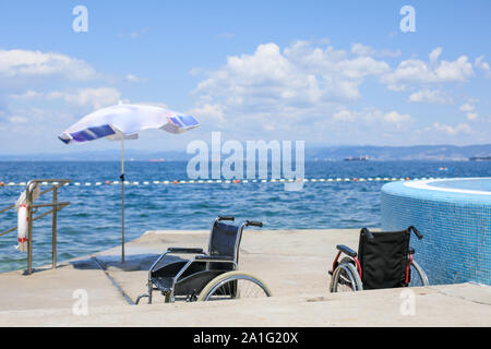 Fauteuil roulant sur une plage accessible pour le transport des personnes handicapées dans l'eau. Banque D'Images