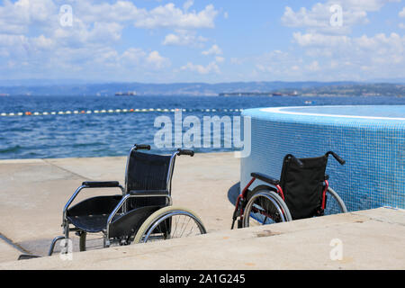 Fauteuil roulant sur une plage accessible pour le transport des personnes handicapées dans l'eau. Banque D'Images