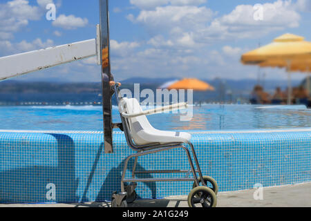 La plage et la piscine adaptée pour personnes à mobilité réduite ascenseur avec les nageurs. Banque D'Images