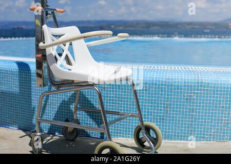 La plage et la piscine adaptée pour personnes à mobilité réduite ascenseur avec les nageurs. Banque D'Images