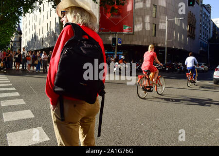 Personnes en attente d'un feu de circulation en rouge alors que les cyclistes passent par une rue du centre-ville. Barcelone, Catalogne, Espagne. Banque D'Images