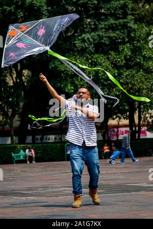 26 septembre 2019, Mexique, Mexiko-Stadt : Un homme soulève un dragon avec le numéro 43, le nom d'un élève-maître disparu et la peinture mains symbolisant les 43 étudiants ont disparu. Cinq ans après leur disparition, de nombreuses personnes ont appelé pour le cas d'une enquête. La police a kidnappé 43 étudiants de l'Ayotzinapa séminaire de formation des enseignants à Iguala dans l'Etat de Guerrero dans la nuit du 27 septembre 2014 et les a remis à la criminal syndicate Guerreros Unidos. Selon les enquêtes officielles, les jeunes hommes ont été tués et brûlés. Des études indépendantes ce doute, cependant. P Banque D'Images