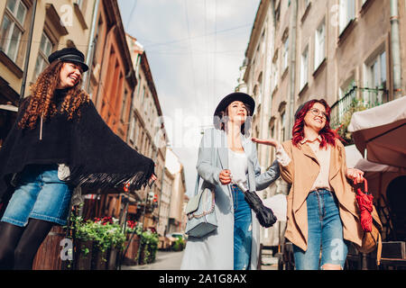 Pour parler et d'avoir du plaisir. Tourné en plein air de trois jeunes femmes marchant sur la rue de la ville. Banque D'Images