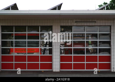 Deux camions de pompiers sont derrière les vitres de plexiglas un garage des pompiers. Banque D'Images