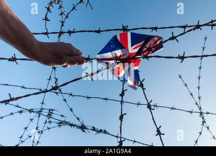 Main et UK Union Jack flag sur les barbelés. Brexit, asile, immigration, contrôle des frontières... concept. Banque D'Images