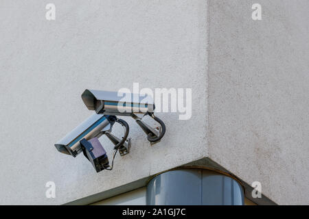 Deux caméras de sécurité mis en place à l'extérieur blanc sale mur de béton rugueux au coin de bâtiment. Banque D'Images