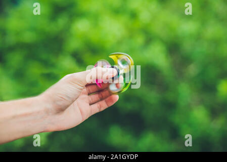 Close up de la main d'un homme qui tient une fidget spinner dans un parc. Banque D'Images