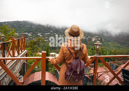 Woman in hat touristique et sac à dos est à la brouillard à Signagi, collines en Géorgie Banque D'Images