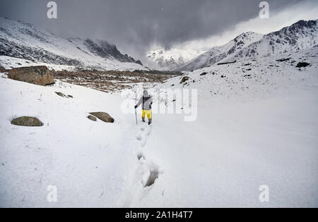 Tourist dans la neige au chemin beau fond de ciel couvert. Concept d'escalade extérieur. Banque D'Images