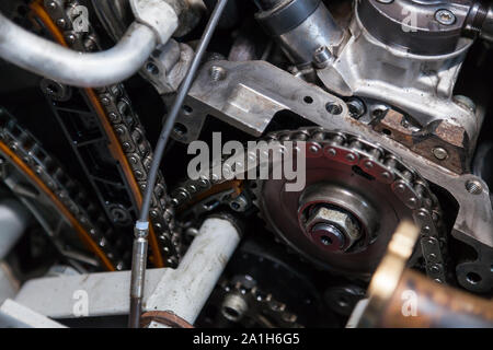 Gros plan sur un moteur démonté avec une vue sur le mécanisme de distribution de gaz, chaîne, pignons et tendeurs pour la réparation et la restauration après un bre Banque D'Images