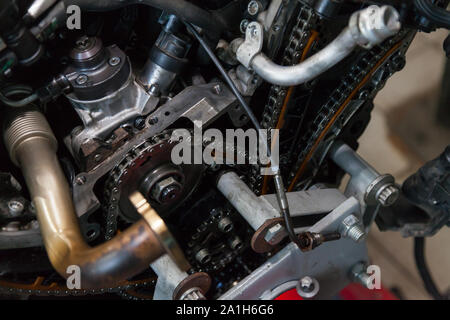 Gros plan sur un moteur démonté avec une vue sur le mécanisme de distribution de gaz, chaîne, pignons et tendeurs pour la réparation et la restauration après un bre Banque D'Images